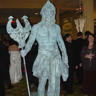 A performer posed as a living statue of Poseidon.
