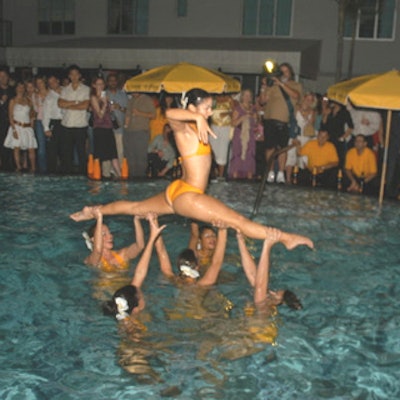 Synchronized swimmers in orange bathing suits performed in the hotel's pool before stepping out to serve champagne.