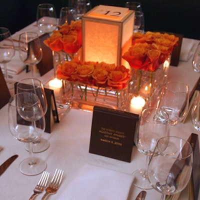 Tables were covered in simple white cloths with centerpieces of parchment-covered table lamps surrounded by cherry brandy roses.