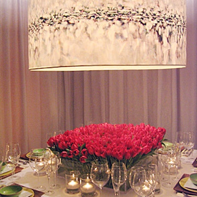 The clean, simple table from Queer Eye for the Straight Guy's Ted Allen and his partner, interior designer Barry Rice, was a pleasant break from the event's fussier looks. The space's centerpiece was 451 red tulips from Holland, each set in a hole drilled into a square Lucite box, topped by a large lampshade four feet in diameter and printed with six photographs by photographers Masood Kamandy and Peter Ross that merged into a continuous image.