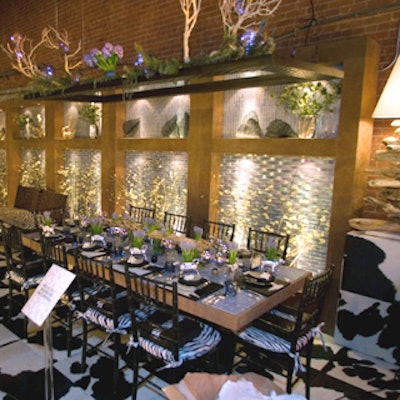 Artistic Tile's founder and C.E.O., Nancy Epstein, used natural materials—like cowhide floor tiles, zebra-print seat covers, and dramatic tall lamps made of stacked driftwood—and the pearlescent finish of the company's blue ceramic tiles, which covered tables and rear walls of the dining space. Chandelierlike sculptures hung over tables and featured branches and wicker balls stuffed with soft blue LED lights.