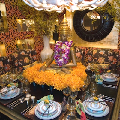 Bold colors and Thai statues were prominent at the table from Barclay Butera and Two's Company/Tozai Home. For a setting that combined Asian influences with a 1960's vibe, Butera played with a yellow, gold, and orange color palette, floral patterns, bright flowers, and Thai statues. The center of attention was a large, seated Thai statue in a bed of mango-colored orchids.