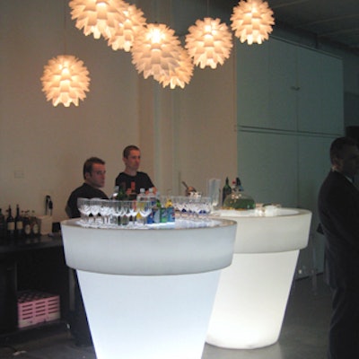 Giant white flower pots with underlit Lucite tops served as bars. Patches of wheatgrass decorated the tops.