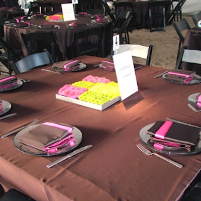Fuchsia and chocolate brown napkins topped the tables alongside square floral arrangements in bright pink, yellow, and green.
