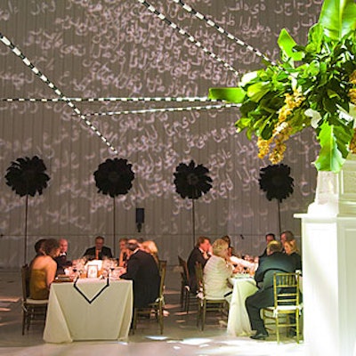 The dinner area was to evoke an imperial palace, with long banquet tables covered with white Egyptian cotton tablecloths and white runners with black edging. Frost Lighting projected Arabic script on the walls.
