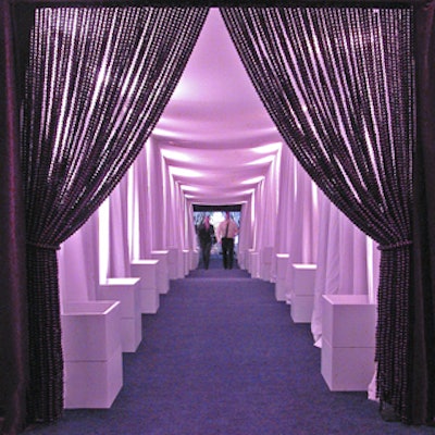 Guests entered the party space through a tunnel of billowing white fabric and deep purple carpet with a wood bead curtain at the entrance.