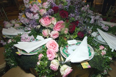 A multitude of roses, lilacs, and vines spilled from the center of the table designed by Flora New York. Flowers, vines, and leaves ran down the sides between each place setting.