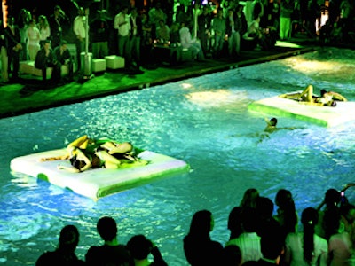 Models in white bikinis decorated white floats in the pool at the Topicana Bar for Xbox 360's party.