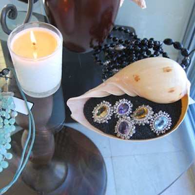 Rings were artfully arranged on a bed of black sand within a large seashell.