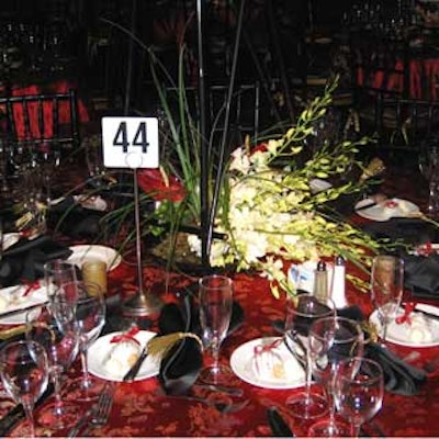 White orchids and bear grass complemented the red embroidered linens on the table.