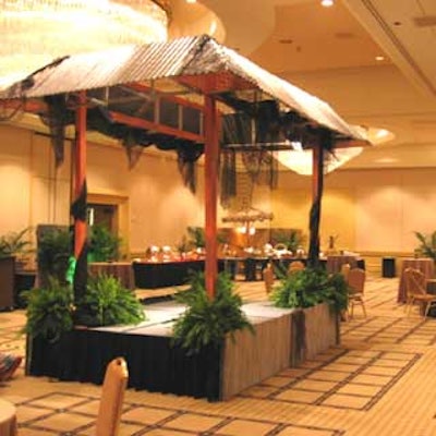 The stage blended in with the swamp-themed ballroom with the addition of foliage, netting, and a tin roof.