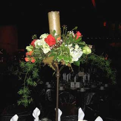 Floral arrangements with candles atop wrought-iron stands decorated the tables.