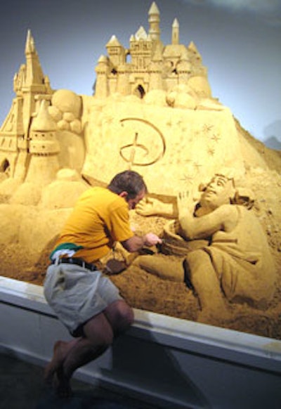 A designer from Team Sandtastic worked on a large Disney sand castle display in one corner of the event.