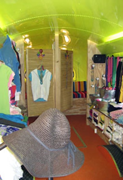 Two changing rooms fitted with saloon doors and benches upholstered in striped fabric sat at the rear of the bus.