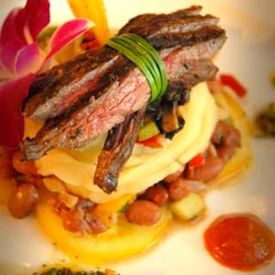 This minimalist presentation featured steak layered with boniato mash and red bean chayote relish, atop yellow tomatoes.