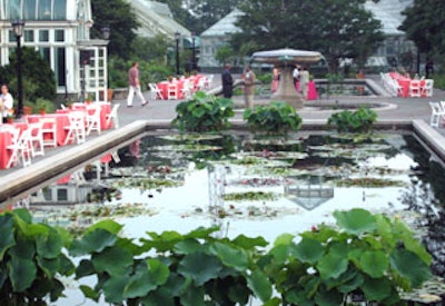 Pink linens draped tables set along the water lily pools in front of the Palm House.