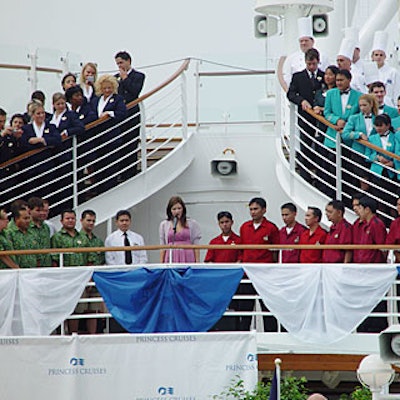 American Idol runner-up Katharine McPhee, who emerged from behind a wall of crew members dressed in solid-colored nautical uniforms, kicked off the ceremony with the national anthem.
