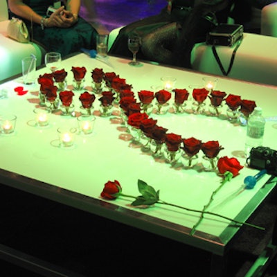 Red roses on coffee tables formed a design resembling the iconic red ribbon symbolizing AIDS awareness.