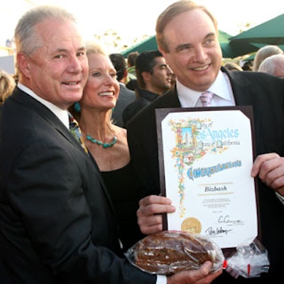 L.A. City Councilman Tom LaBonge, BiZBash founder and C.E.O. David Adler, and BiZBash West Coast president Elisabeth Familian pose for a photo with the commendation that was awarded to BiZBash, along with a loaf of pumpkin bread that was made by an order of L.A. nuns and is traditionally presented to new businesses as a welcoming gesture.