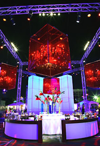 A truss structure lit by a constantly changing swirl of colors surrounded a circular bar.