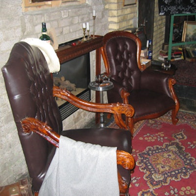 Antique leather arm chairs flanking a fireplace helped create the atmosphere of a 20's social club for seniors.