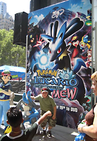 Fans posed for pictures in front of a promotional sign for the new movie Pok?mon: Lucario and the Mystery of Mew.