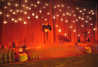 Two hundred lit votive candles created a backdrop for the back bar at the event’s after-party.