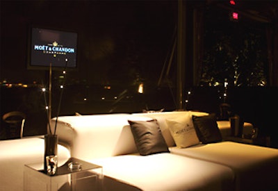 The party's V.I.P. area featured white leather couches, accented by branded pillows and wooden sticks with mini lights.