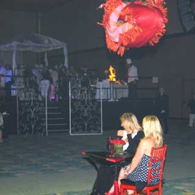 A performer from Cirque USA wearing pogo-stick-like shoes flipped over a pair of guests.