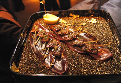 New York Caterers served hors d’oeuvres on trays with gold and black beads and flecks of gold.