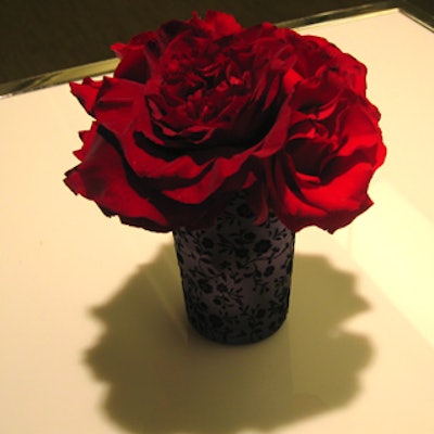 Small bouquets of roses filled frosted vases decorated with velour floral prints.