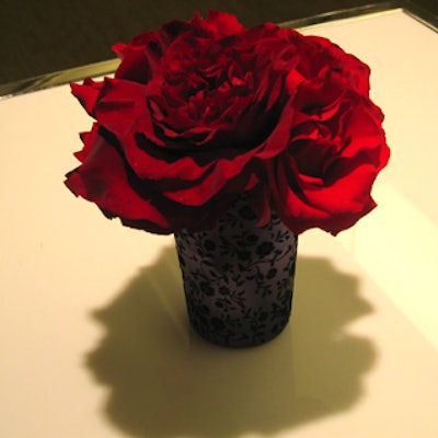 Small bouquets of roses filled frosted vases decorated with velour floral prints.