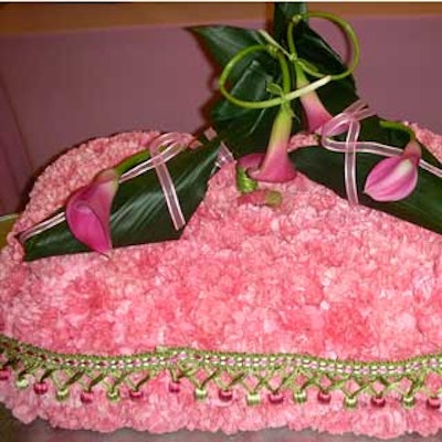 A Joy Wallace Catering Production & Design Team's in-house floral department created a replica of a pair of shoes sitting on a decorative pillow out of flowers and foliage for the 2006 Key to the Cure kickoff party.