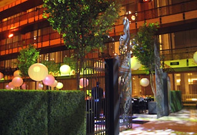 The entryway to the dinner area was marked by a baroque-style garden gate structure flanked by artificial hedges.