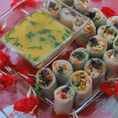 Red carnations decorated clear glass serving trays used to pass lobster salad rolls.