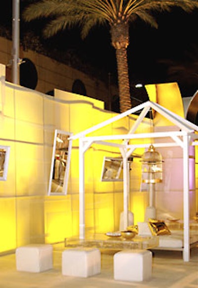 White doves roosted in gold cages above white lounge furniture.