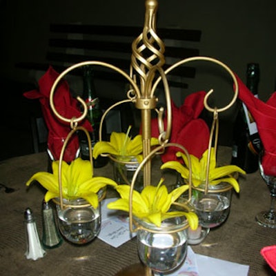 A variety of centerpieces adorned tables. Here: flowers were used to accent the gold decor piece.