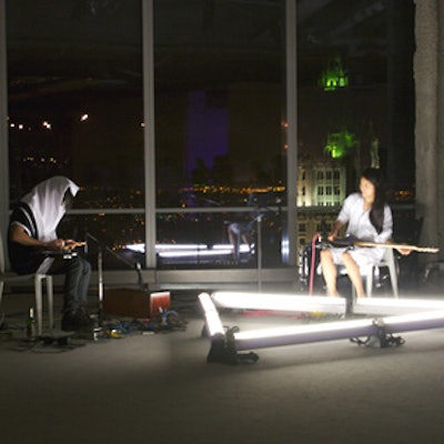 During cocktails, the collaborative multimedia group New Humans performed experimental sound compositions amid its site-specific triangular light sculpture.