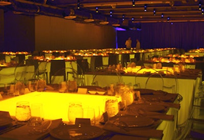 A grid of square and circular tables lined the dining space. Solid circles of light shone on circular tables, solid illuminated squares lit square tables, and light emanated through the table covering.