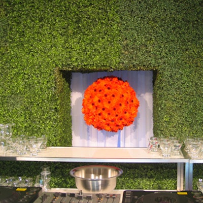 A sphere of faux orange flowers that hung from the wall above the bar stood out against the white-and-green backdrop.