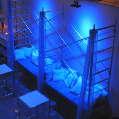 Guests sat on a bench in a blue-lit scaffold vignette.