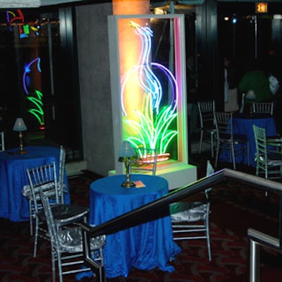 Tropical neon signs paired with Panache's cool silver and blue table settings added to the Art Deco look.
