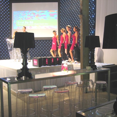 Models in pink dresses from stood on stage during the media conference.