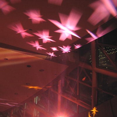 Star-shaped lighting in various shades of fuchsia rotated from the floor to the ceiling.