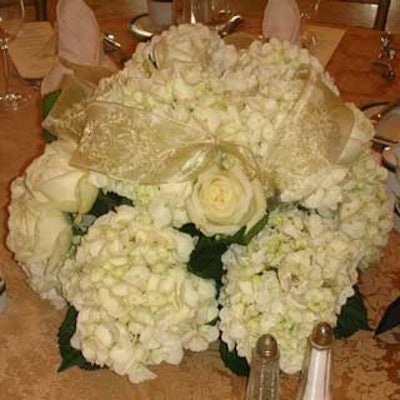 Ron Weeks of Weeks Floral matched the color scheme with centerpieces of white flowers and gold ribbon.