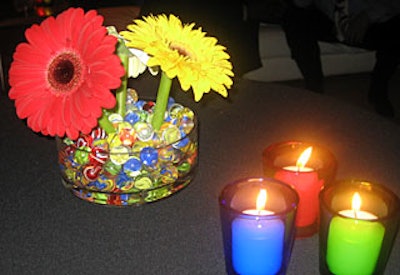 Colorful gerbera daisies were arranged in marble-filled containers.
