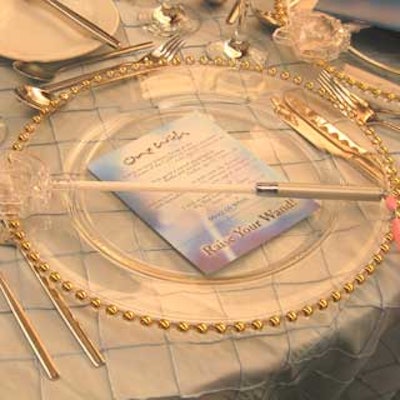 Clear plastic wands and cards of children's wishes adorned clear glass charger plates at each place setting.