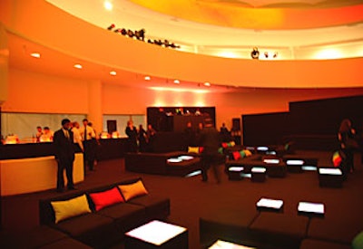 Vibrant pillows and glowing cube tables provided a shot of color in the decor’s otherwise simple, all-black look.