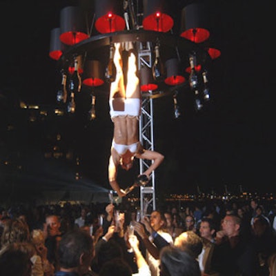 A woman suspended from a chandelier served champagne to those around her.