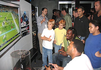 Pro NFL-ers Vernon Davis (seated left) and Michael Clayton (seated right) represented the Colts and the Bears, respectively, while playing Madden 2007 in the Playstation3 lounge.
